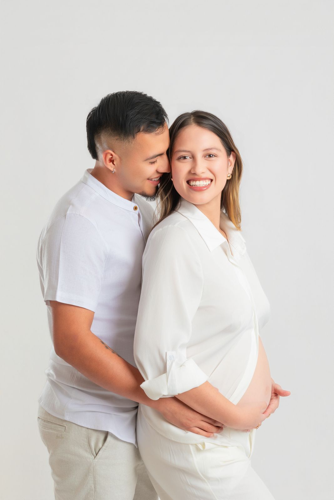 Sesión de embarazo en estudio, la pareja se abraza